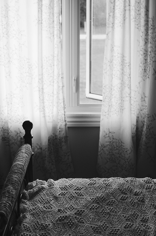 Black and white curtain and window with crocheted blanket
