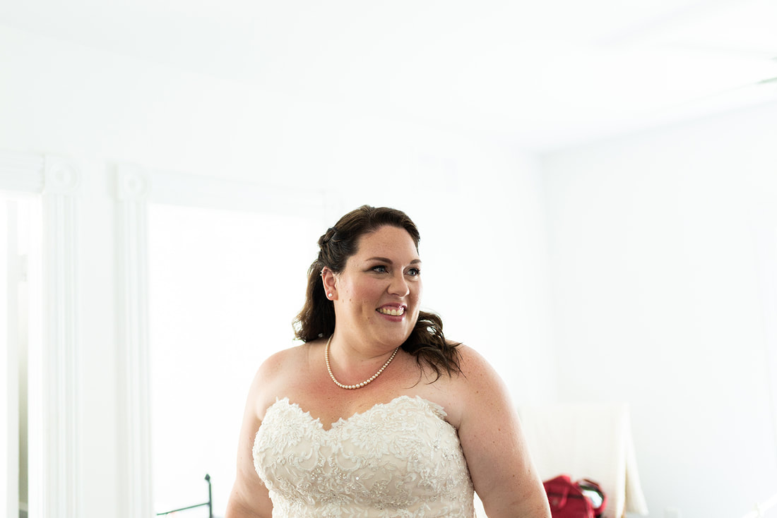 Bride smiling in a white room at her wedding in Lyndhurst